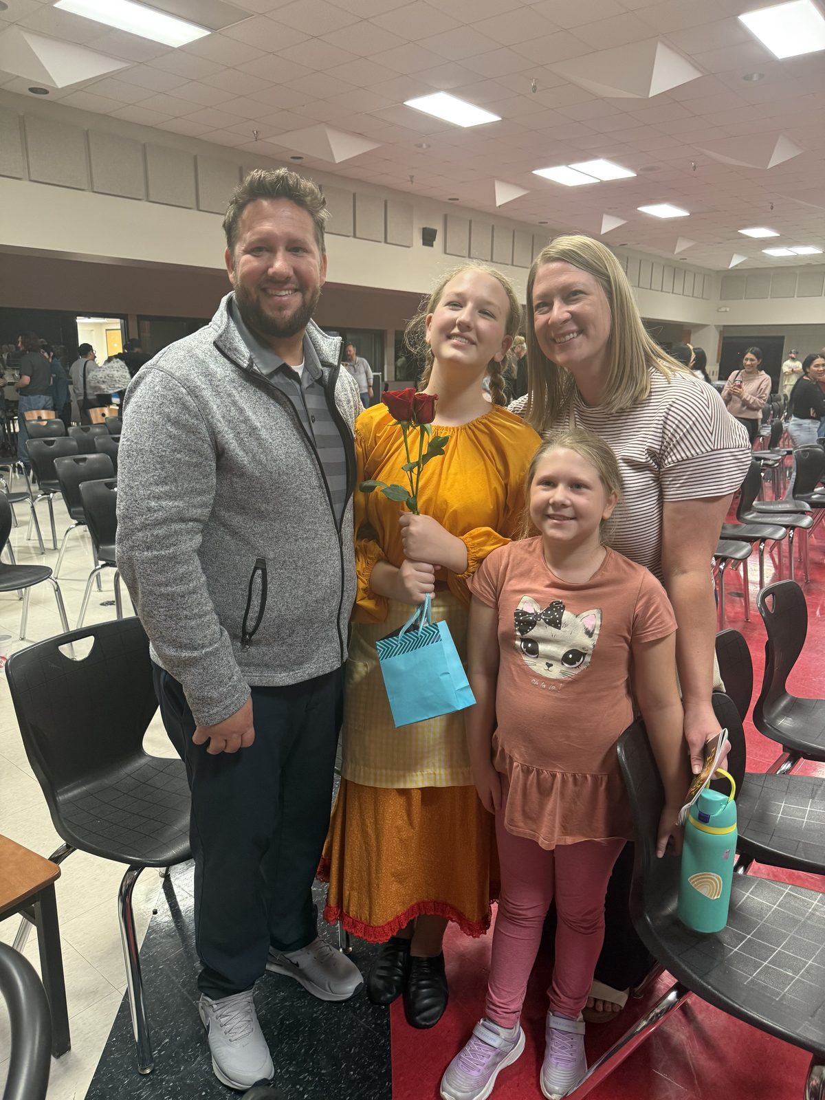 John with his wife and two daughters after a school performance